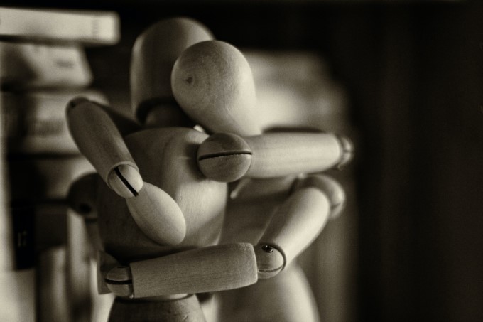 Two wooden dummy figures hugging